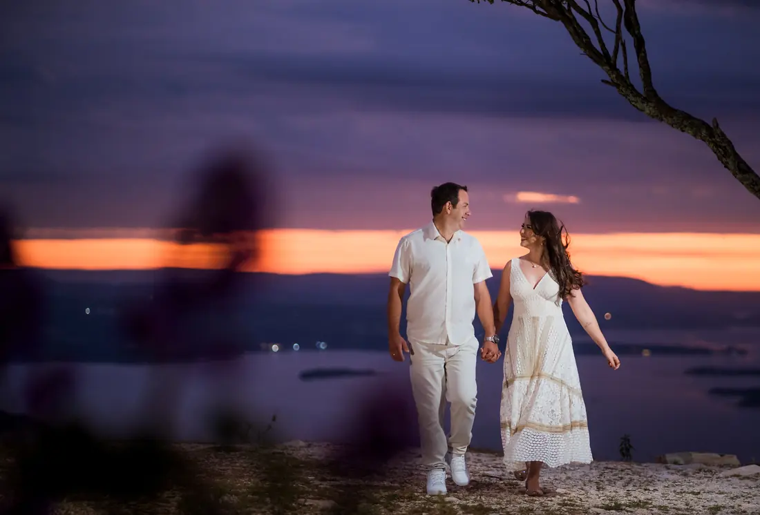 Casal caminhando ao entardecer em ensaio romântico