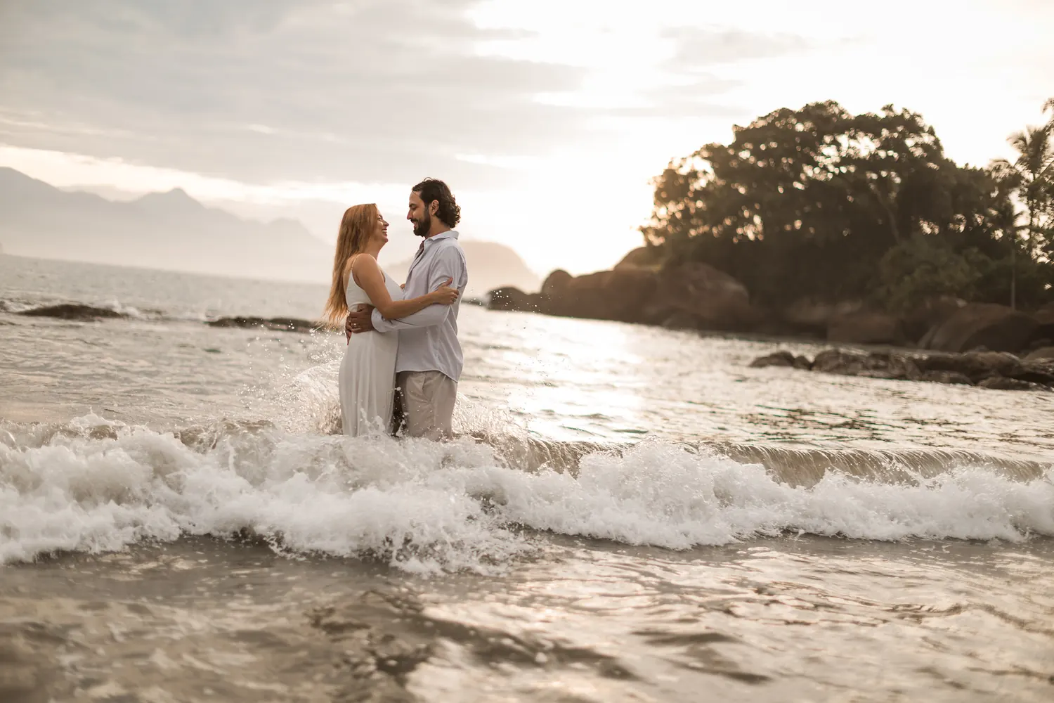 Casal no mar durante ensaio romântico na praia