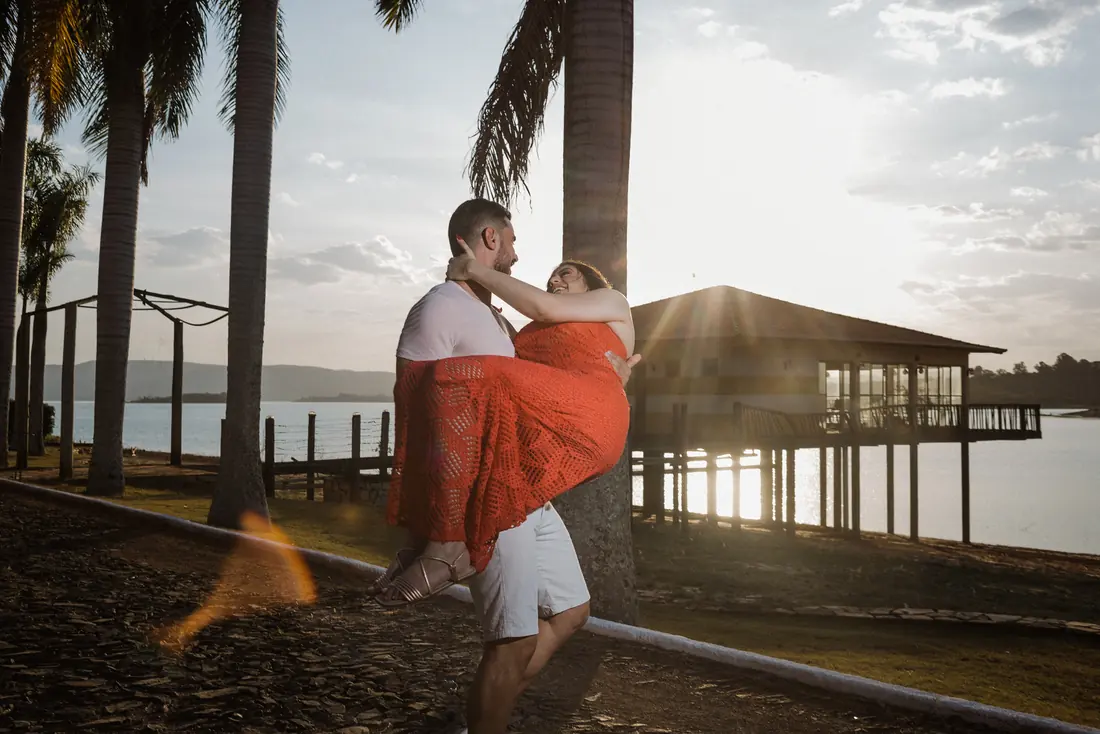 Casal em ensaio à beira do lago com luz dourada