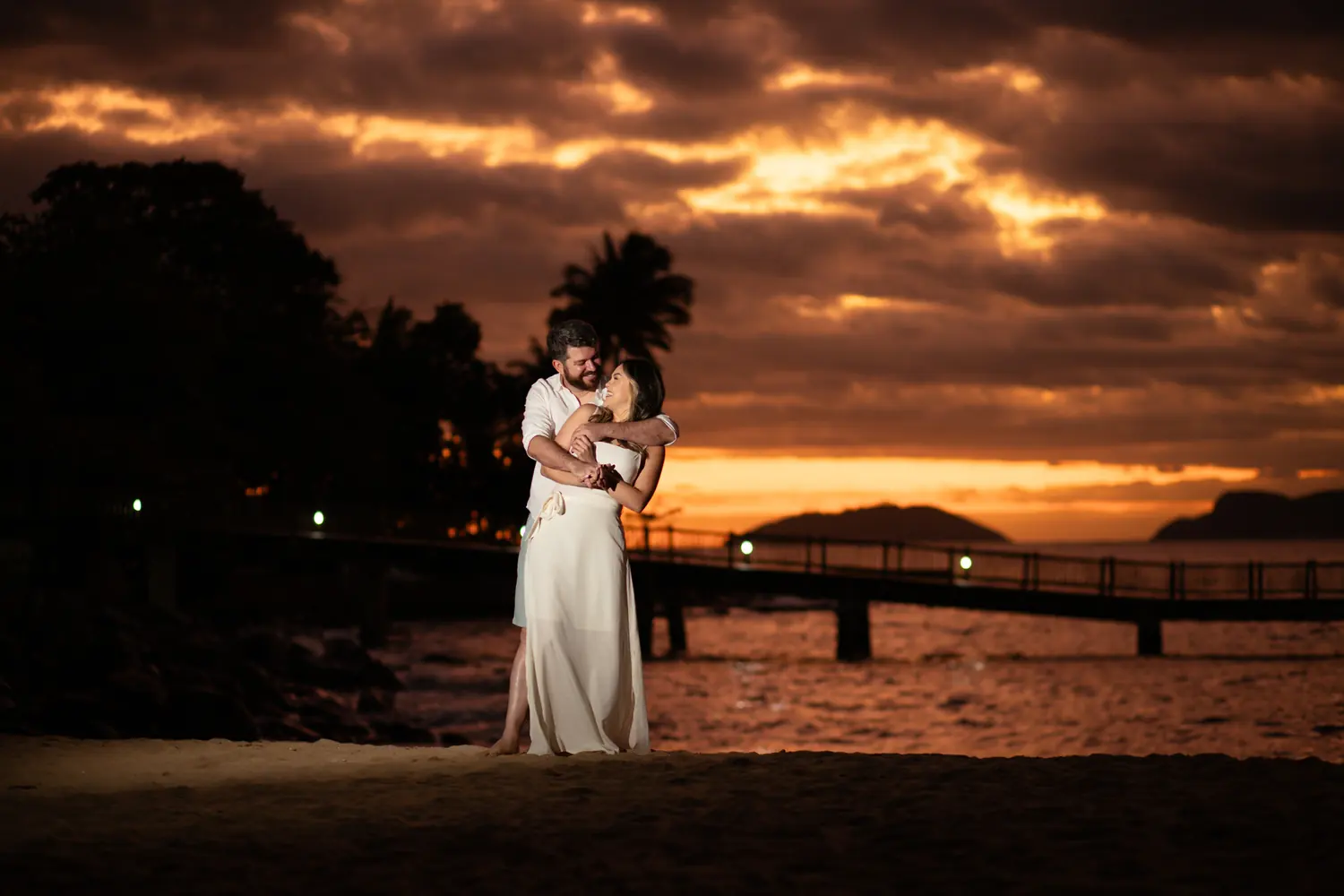 Casal abraçado ao pôr do sol na praia