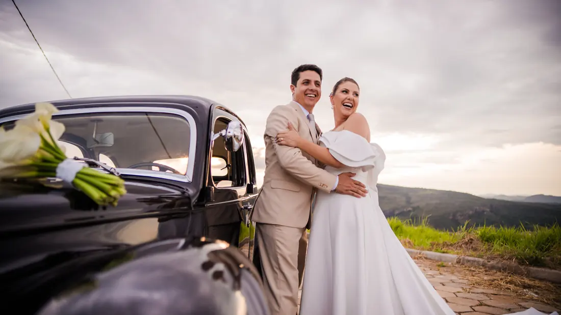 Casal ao lado de carro clássico após a cerimônia